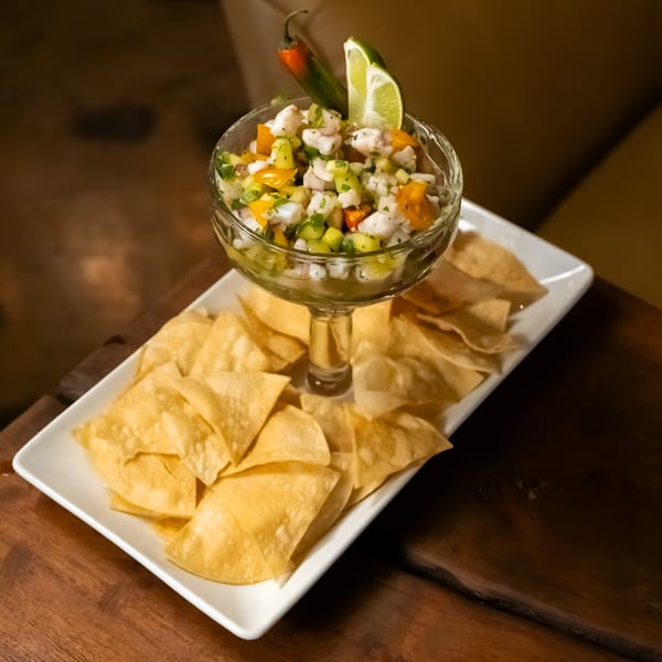 Starlite Restaurant and Bar's ceviche with lime, chili, and tortilla chips on a wooden table.